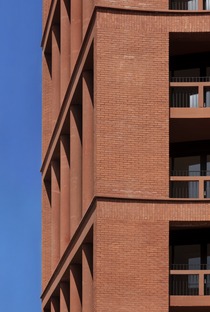 Torre de apartamentos con escuela, de ladrillos, cemento y madera
