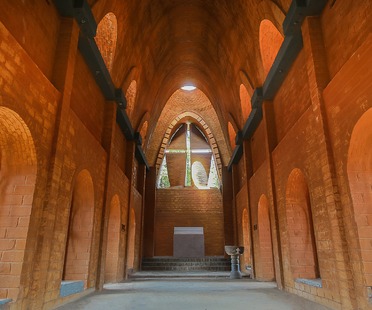 Iglesia con arcos de catenaria y ladrillos de tierra cruda, por Wallmakers
