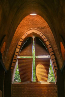 Iglesia con arcos de catenaria y ladrillos de tierra cruda, por Wallmakers
