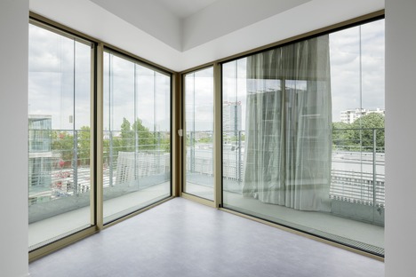 Apartamentos de interés social, de vidrio y cemento, por Atelier Kempe Thill
